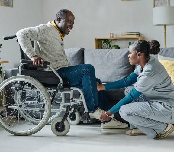 Caregiver assisting patient in wheelchair at home